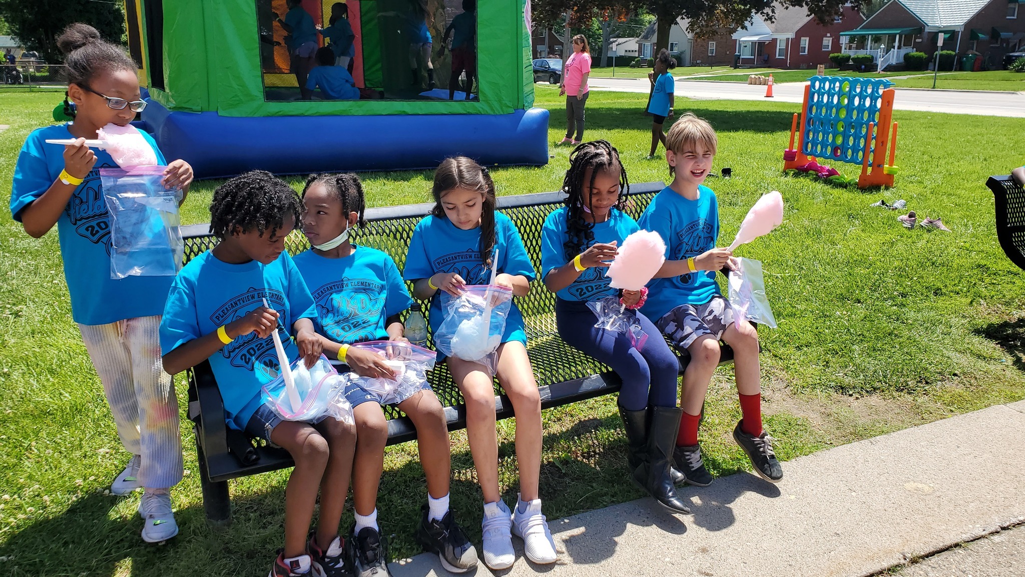 Pleasantview students sit on a bench and eat cotton candy
