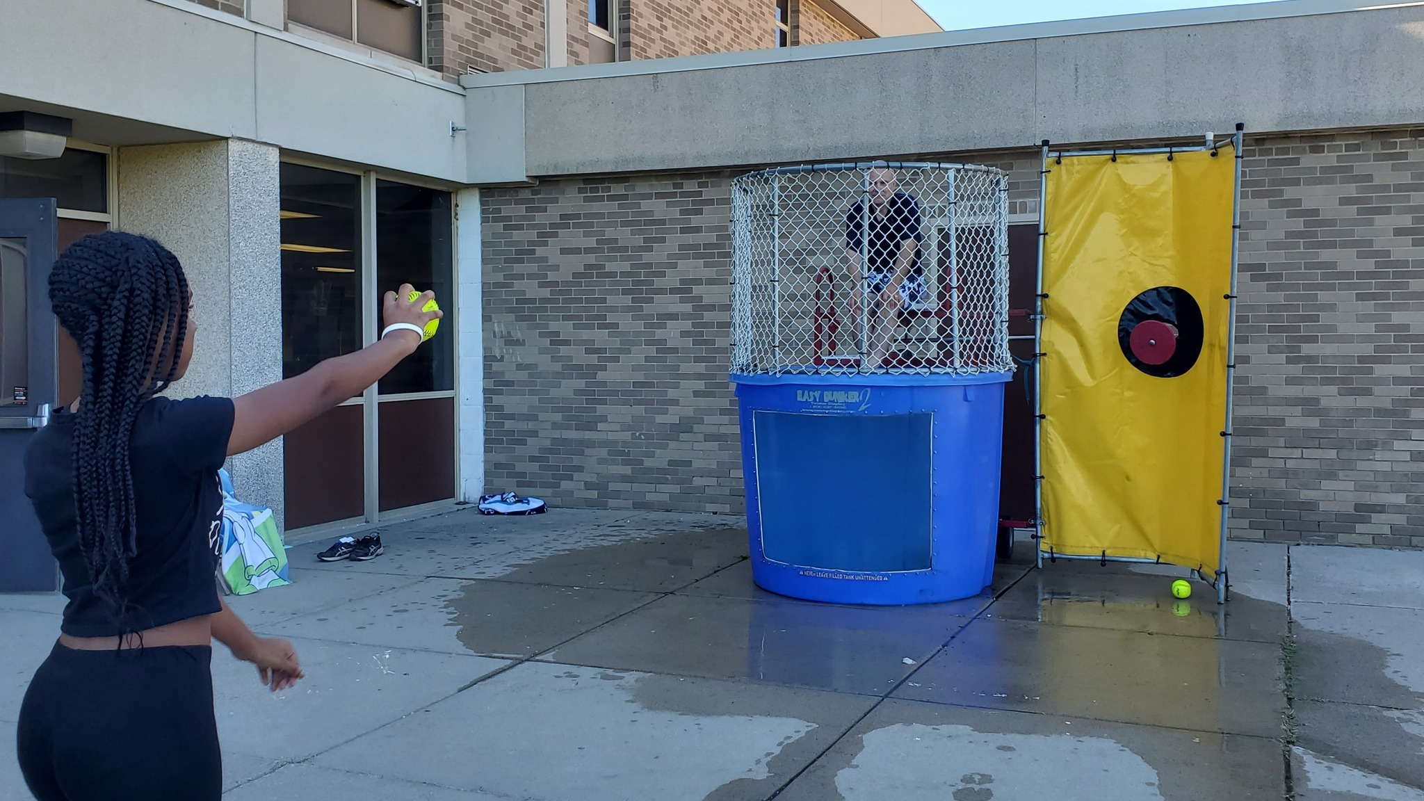 Middle school student prepares to throw a softball at a dunk tank